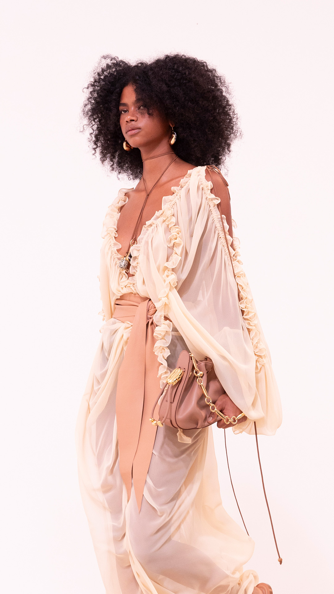 Look 6: Illuminate Draped Dress in Tea, Ore Zebra Hoops in Gold/Black, Ore Lariat Necklace in Gold, Zing Anklet in Gold, Zing Chain Anklet in Gold, Foam Wrap Belt in Caramel, Halcyon Clutch in Biscuit and Wild Sandal in Caramel 