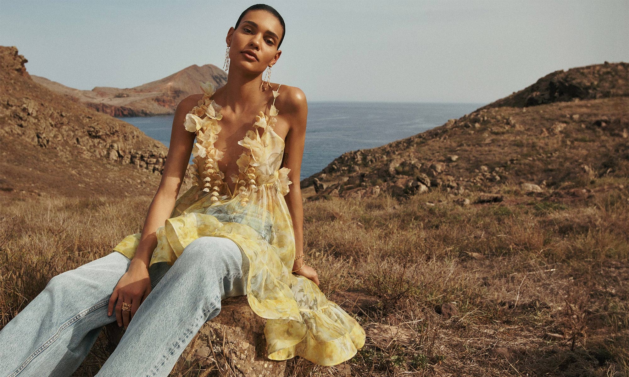 Model wears the Harmony Asymmetrical Dress in Yellow Peony, Natura Oversize Barrel Jean in Sea Spray, Zimmermann Midnight Earrings in Gold, Zimmermann Laurel Bracelet in Gold and Zimmermann Bloom Band Ring in Gold/Green 