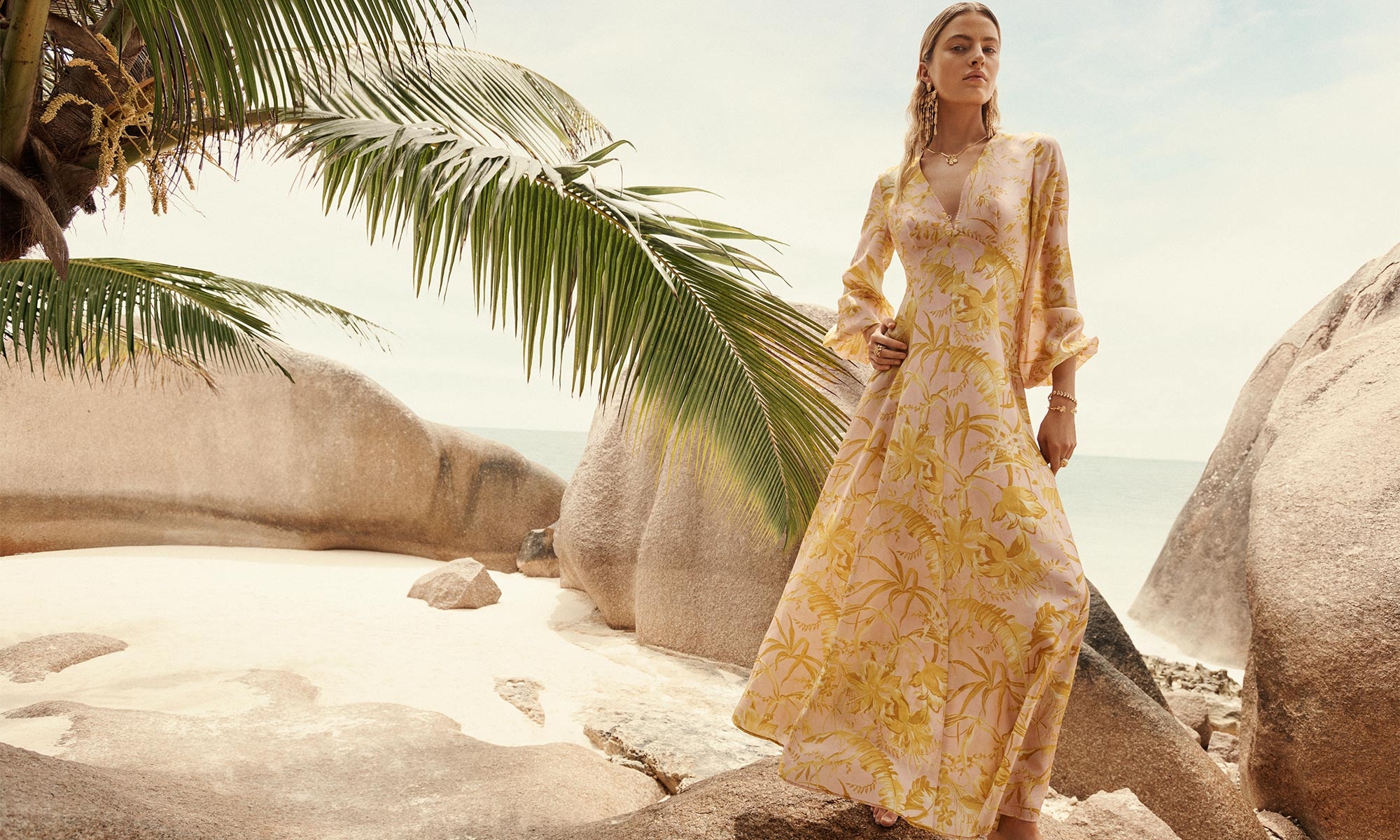 Model wears the Golden Long Sleeve Maxi Dress in Pink/Gold Floral, ZIMMERMANN Midnight Chandelier in Gold, ZIMMERMANN Natura Pendant in Gold/Agate, ZIMMERMANN Bloom Cuff, ZIMMERMANN Laurel Bracelet, ZIMMERMANN Bloom Band Ring and ZIMMERMANN Bloom Ring 