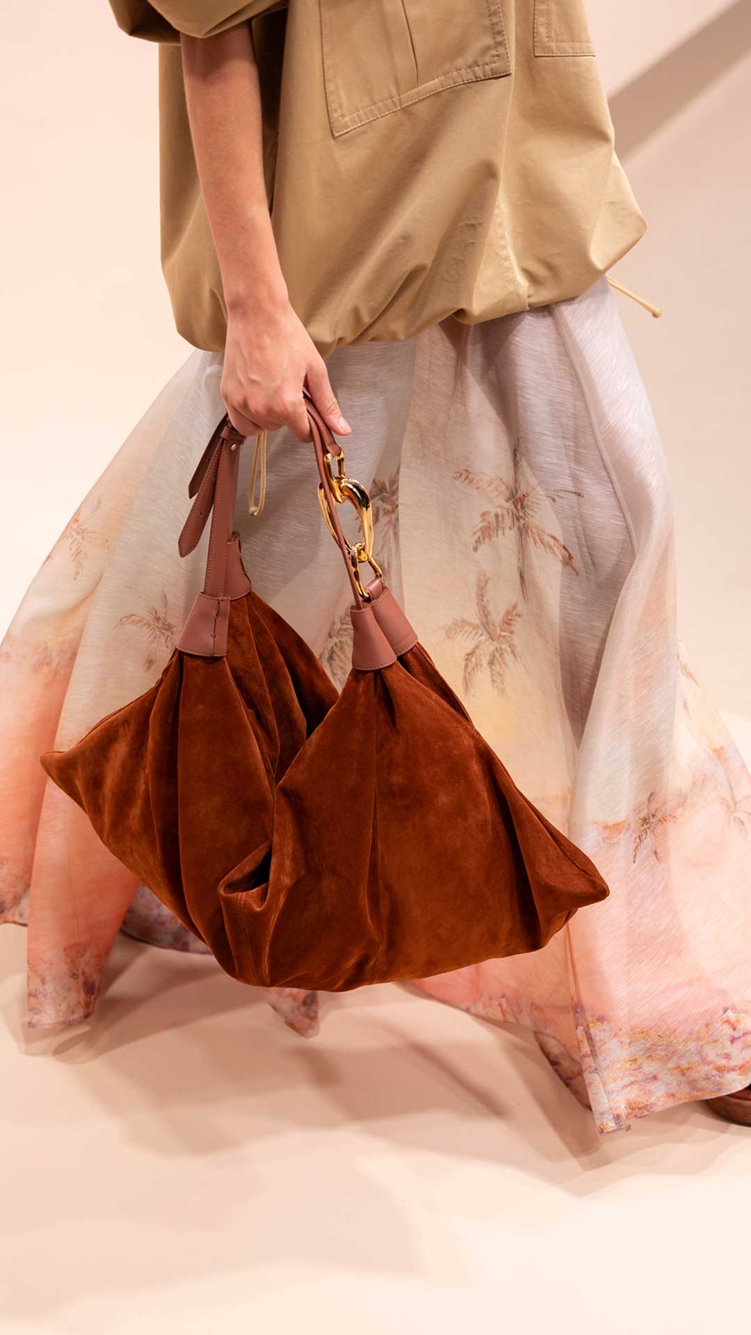 Look 26: Illuminate Cargo Anorak in Sand, Illuminate Maxi Skirt in Guava Seascape, Mellow Pearl Beaded Necklace in Gold/Multi, Beaded Bandana Scarf in Orange/Brown, Trampoline Hobo in Tan and Wild Wedge 95 in Pecan 