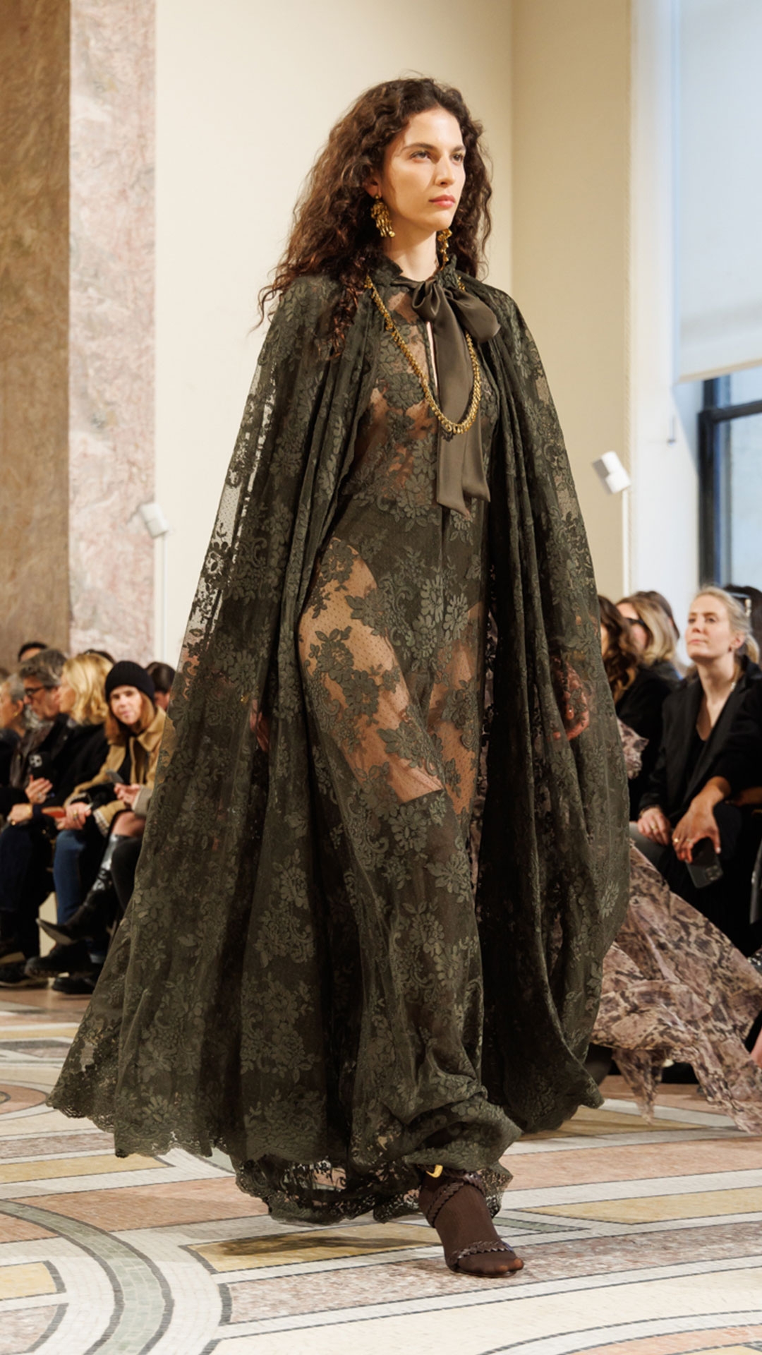 Look 37: Memento Lace Maxi Dress in Olive, Memento Lace Cape in Olive, Whimsy Chandeliers in Antique Gold, Whimsy Single Earcuff in Antique Gold, Whimsy Necklace in Antique Gold and Helix Sandal 75 in Chocolate 