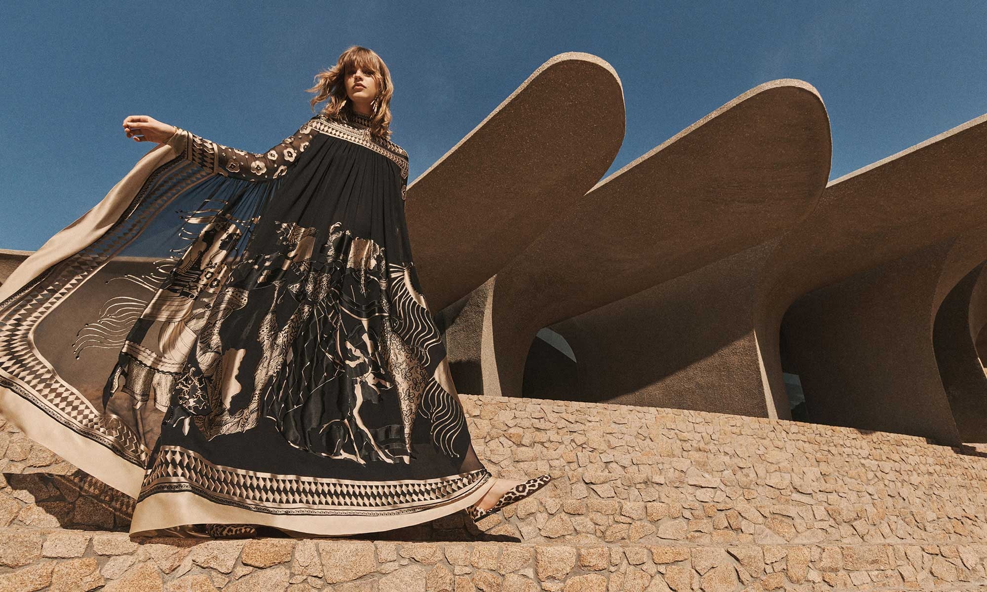 Model wears the Illustration Otto Gown in Black/Tea, Zimmermann Stella Chandeliers in Gold/Black and Zimmermann Gleam Ballerina in Leopard 