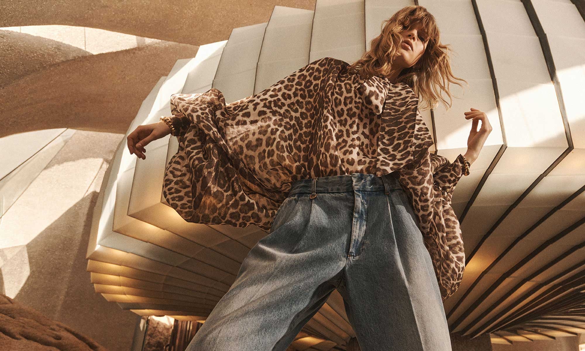 Model wears the Illustration Billow Blouse in Chocolate Leopard, Illustration Denim Pant in Neptune and Zimmermann Deco Cuff in Gold 