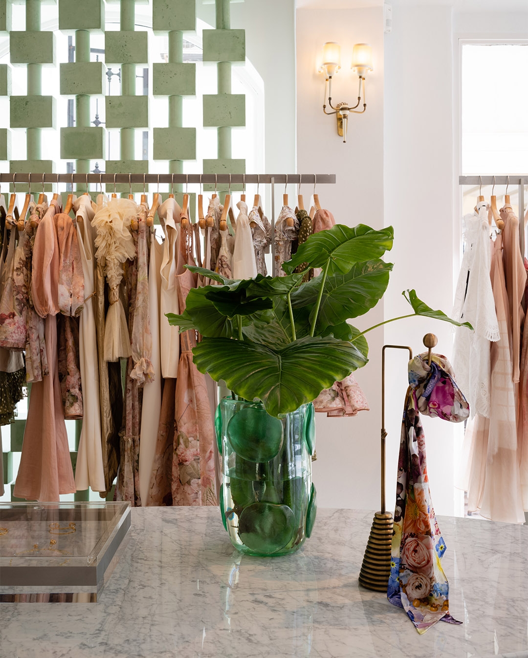 Store details, a vase with palms and scarf on accessories stand