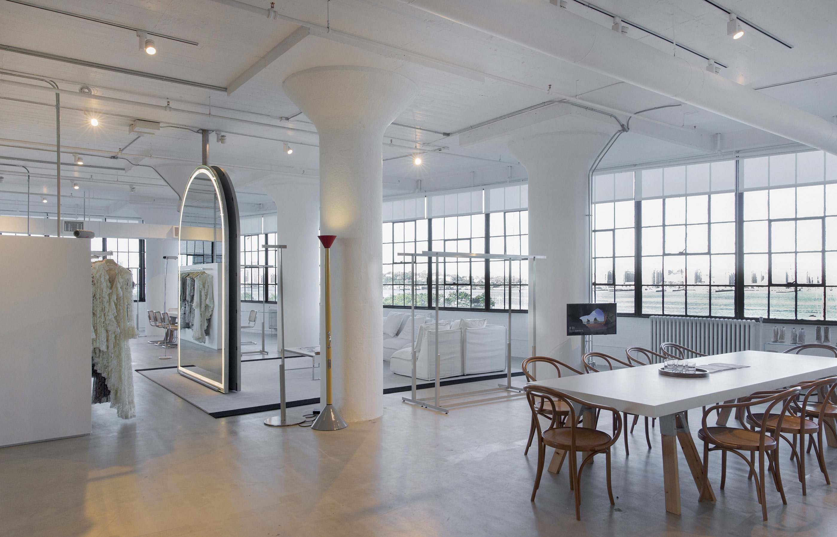 A mirror, meeting table, couch and clothing racks in our modern New York Office