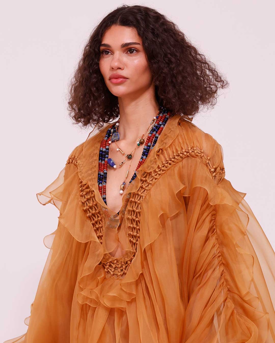Look 52: Balance Braided Gown in Tan, Mellow Stone Beaded Necklace in Gold/Multi, Mellow Stone Necklace in Gold/Multi, Wild Sandal in Espresso and Rapture Clutch in Gold 