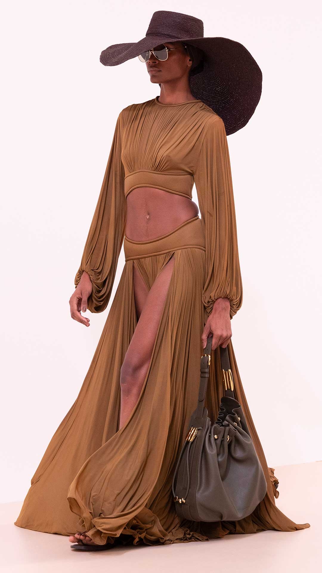 Look 15: Balance Batwing Bodice in Khaki, Balance Maxi Skirt in Khaki, Long Brim Sunhat in Espresso, Halcyon Large Bucket in Jungle Green, Wild Sandal in Espresso and Amee Oversize in Moss 