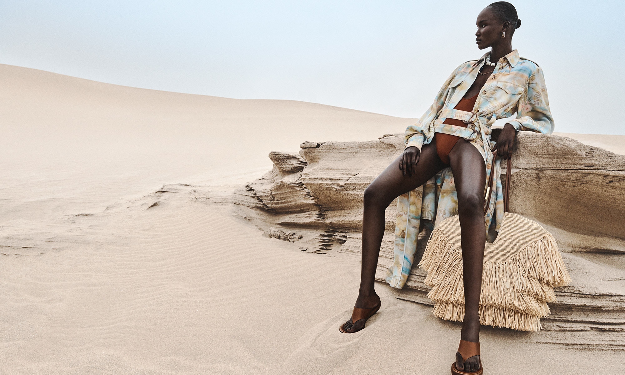 Model wears the Illuminate Cargo Midi Dress in Blue Morning, Dawning Scoop Bodysuit, Wild Wedge 95 in Pecan, Mellow Pearl Beaded Necklace in Gold/Multi, Mellow Stone Beaded Necklace in Gold/Multi, Glaze Hoops in Gold and Goldentime Medium Fringe Tote 