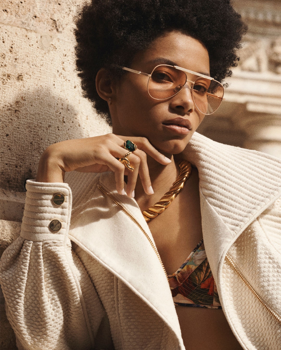 Our model wears gold rimmed aviator sunglasses & a pink tint to the lenses 