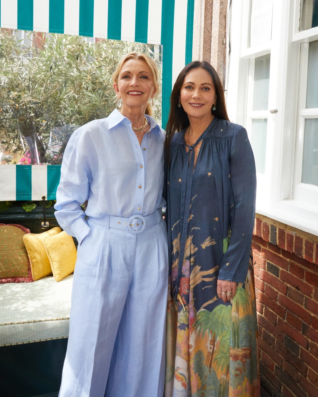 Simone wears the Tama Button Up Shirt and Tama Wide Leg Pant. Nicky wears the Lyrical Sheath Dress from the upcoming Fall 2023 collection. 