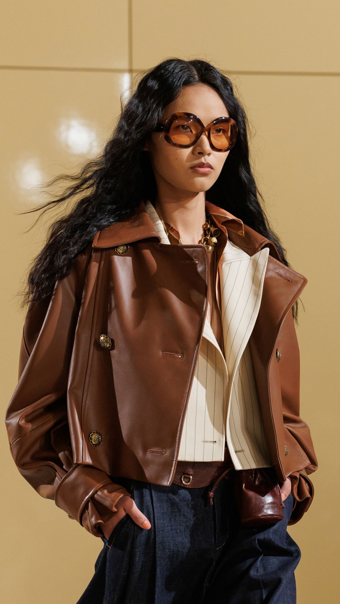 Look 6: Hypnotic Leather Crop Trench in Tan, Hypnotic Pinstripe Blazer in Cream Pinstripe, Hypnotic Stripe Shirt in Pecan Stripe, Hypnotic Denim Tailored Pant in Night Sky, Helix Belt 100, Whimsy Charm Necklace, Whimsy Pendant, Helix Sandal 75 