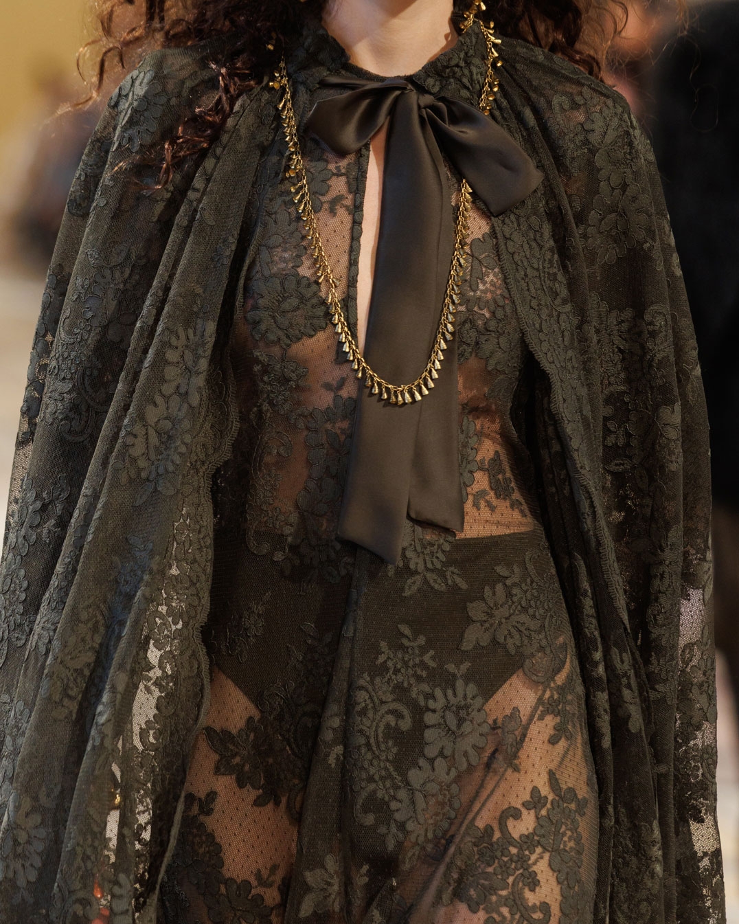 Look 37: Memento Lace Maxi Dress in Olive, Memento Lace Cape in Olive, Whimsy Chandeliers in Antique Gold, Whimsy Single Earcuff in Antique Gold, Whimsy Necklace in Antique Gold and Helix Sandal 75 in Chocolate 