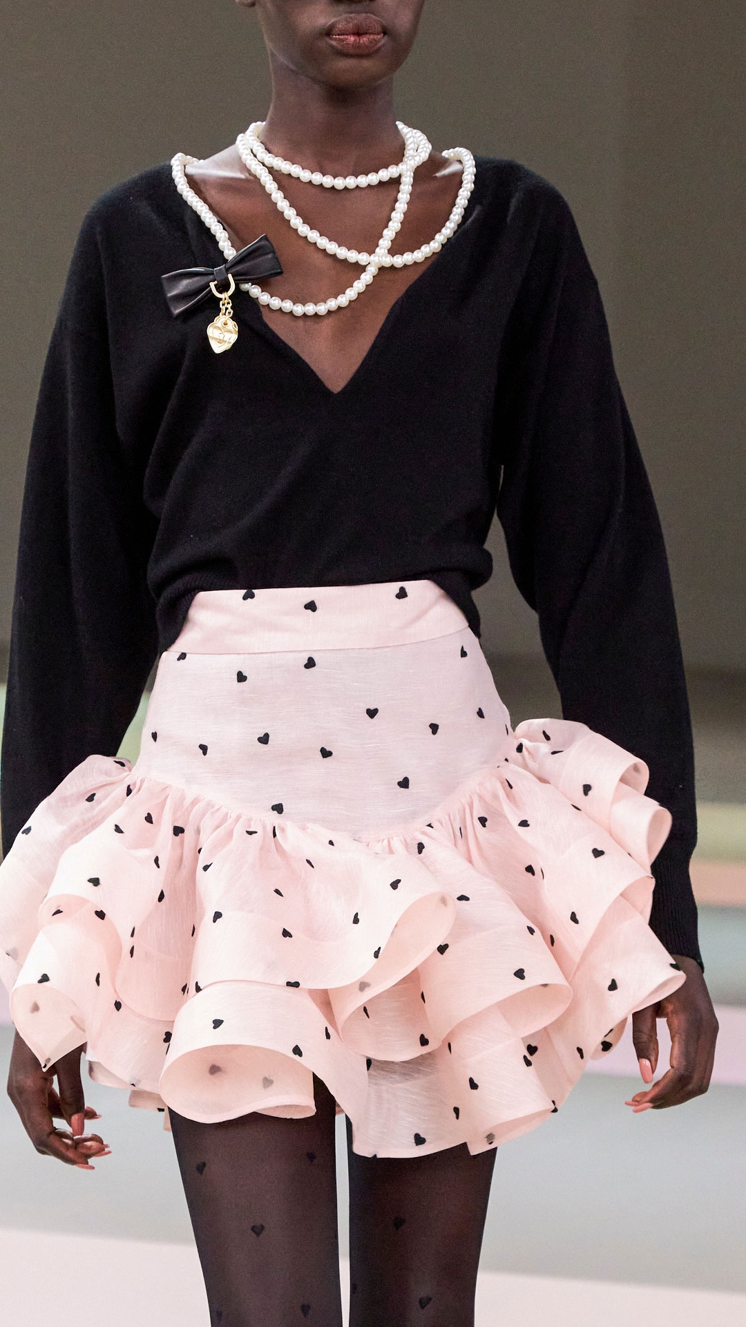 LOOK 17: CRUSH NECKLACE SWEATER IN BLACK, CRUSH FLIP MINI SKIRT IN PINK HEARTS, EMBELLISHED HAIR BARETTE IN BLACK, EMBELLISHED HAIR PIN SET IN SILVER, VEIL HEADBAND IN BLACK AND ZIMMERMANN TUX MULE 65 IN BLACK 