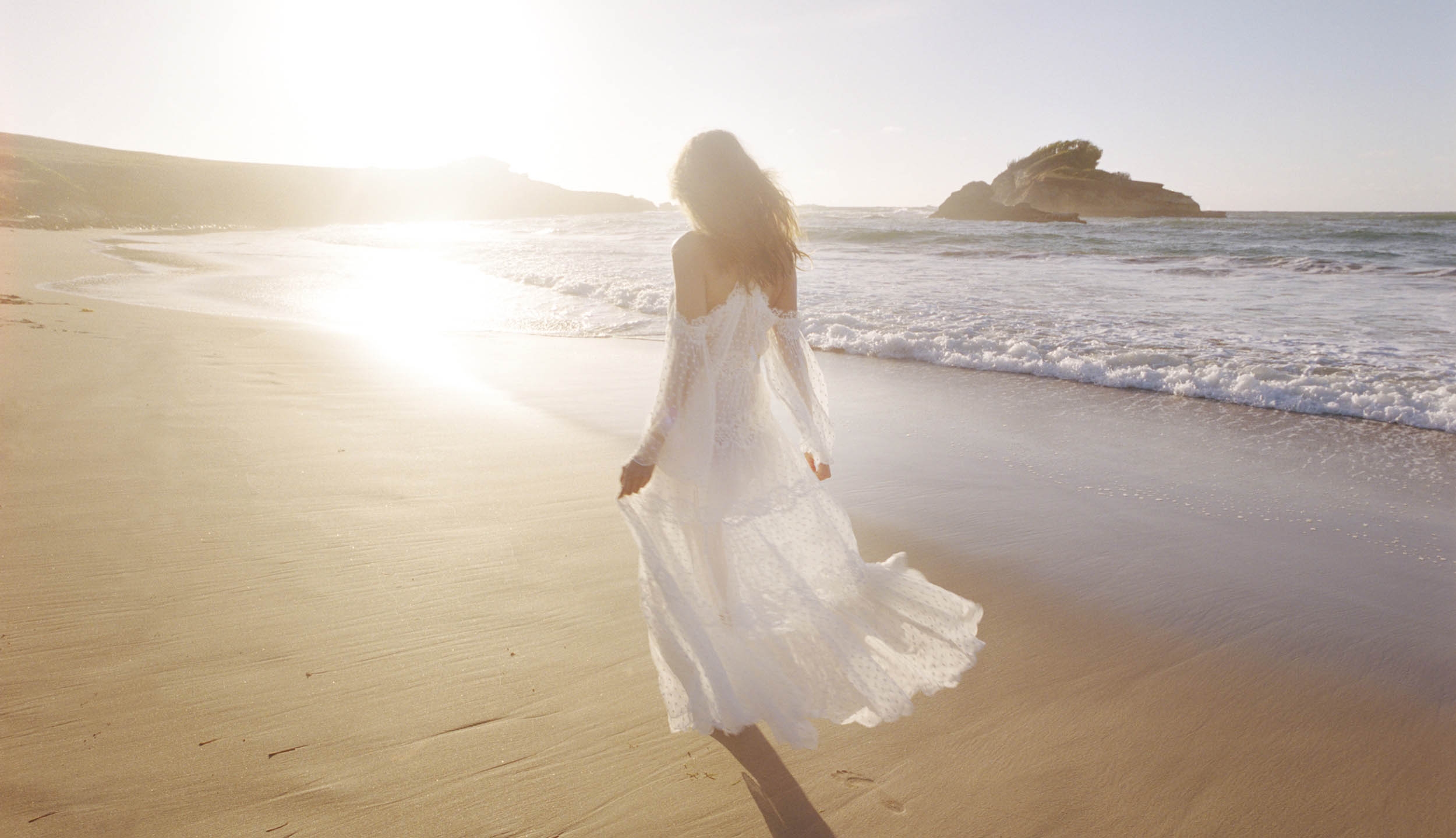Walking along the beach in Look 1 of the Capsule Collection